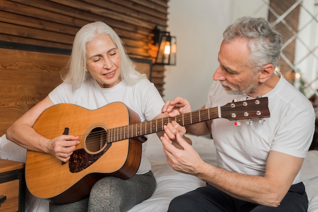 Husband teaching wife to play quitar