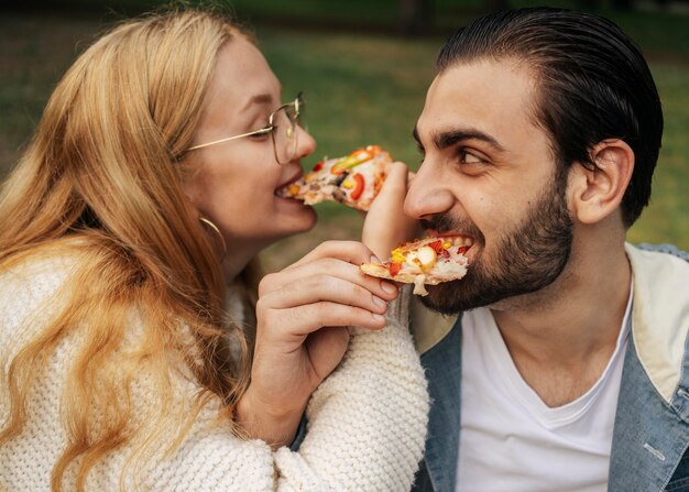 Муж и жена едят пиццу