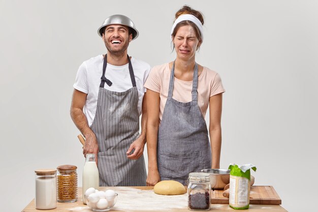 Husband and wife pose in the kitchen preparing tasty dinner