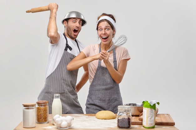 Husband and wife pose in the kitchen preparing tasty dinner