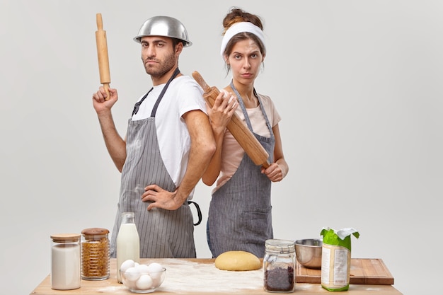 Marito e moglie pongono in cucina a preparare una gustosa cena