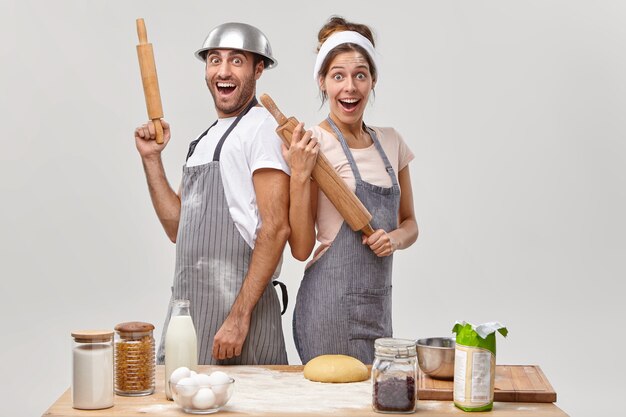 Husband and wife pose in the kitchen preparing tasty dinner