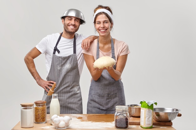 Husband and wife pose in the kitchen preparing tasty dinner