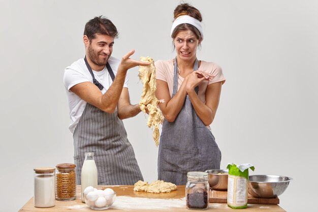 Husband and wife pose in the kitchen preparing tasty dinner