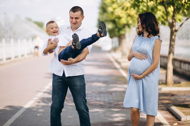 Husband with pregnant wife and their son in park