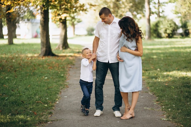 Husband with pregnant wife and their son in park