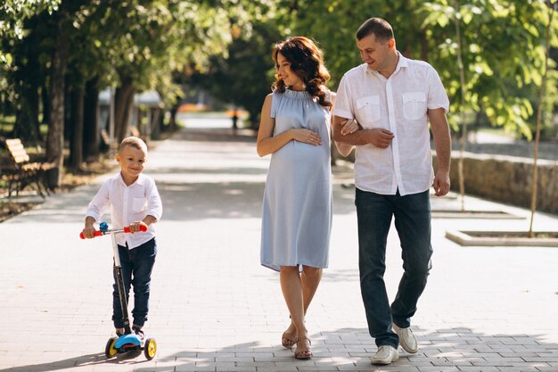 Husband with pregnant wife and their son in park