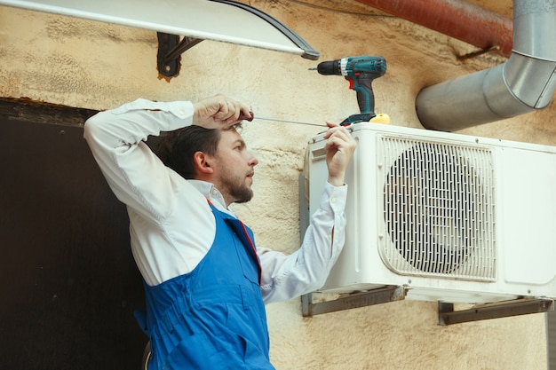 Free photo hvac technician working on a capacitor part for condensing unit