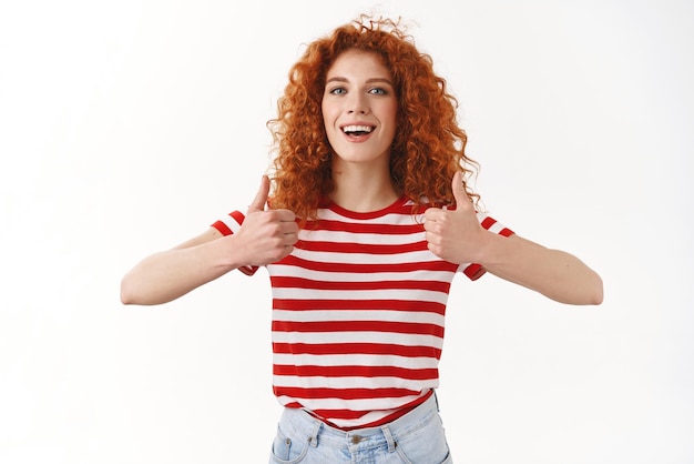 I agree good choice Attractive charismatic satisfied redhead curlyhaired female approve fantastic work hairdresser show thumbs up smiling broadly express like approval good attitude recommend