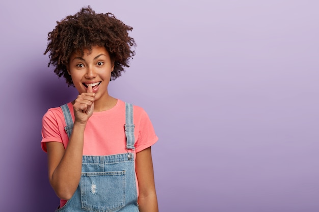 Free photo i am telling you. young afro american woman shows sign to bet, gives wager