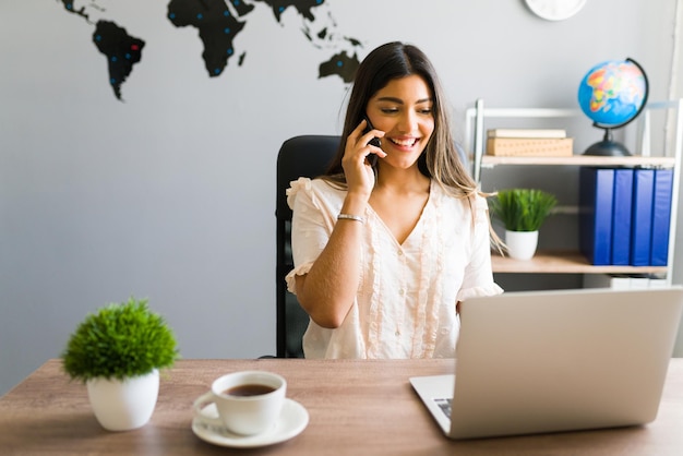 A remote customer service representative working from home with a laptop, headset, and a world map in the background, symbolizing global connectivity