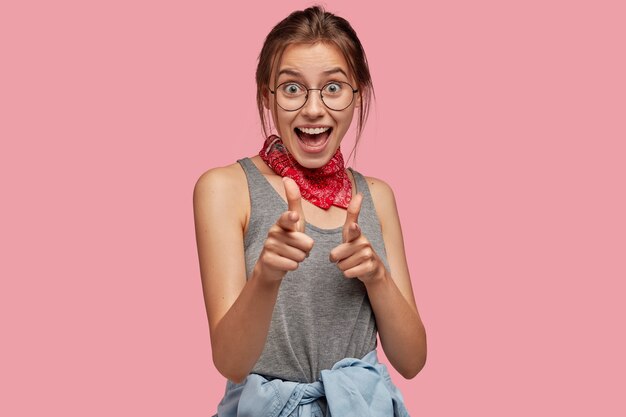 Foto gratuita io ti ho scelto. bella donna europea fa il gesto della pistola, punta direttamente alla telecamera