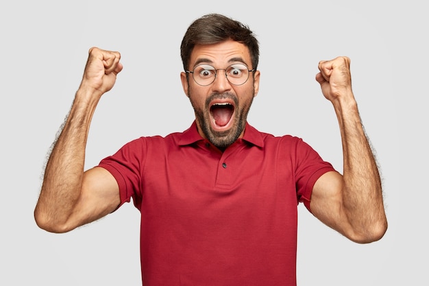 Free photo i feel like champion! attractive joyful european man celebrates his success