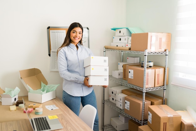 I have a growing business. Portrait of a beautiful female entrepreneur smiling and making eye contact while preparing packages ready to ship to customers