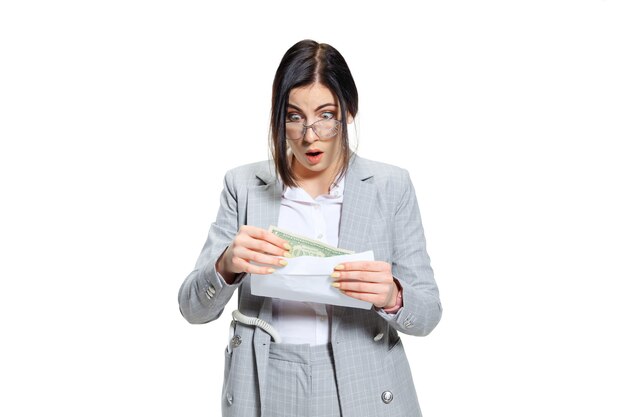 I hope it's just a joke. young woman in grey suit getting a small salary and not believing her eyes. shocked and outraged. concept of office worker's troubles, business, problems and stress. Free Photo