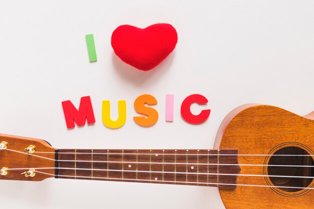 Free photo i love music colorful text with wooden guitar on white background