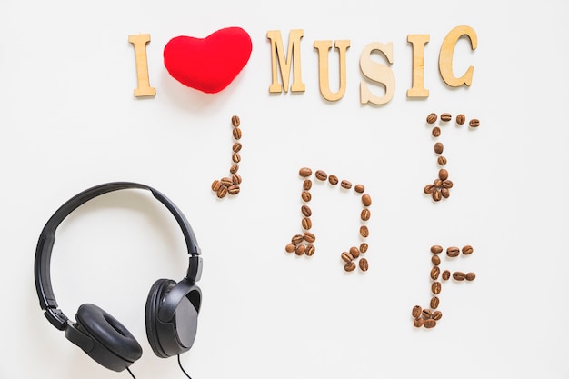 Foto gratuita adoro il testo musicale con chicchi di caffè e cuffie musicali arrostiti su fondo bianco