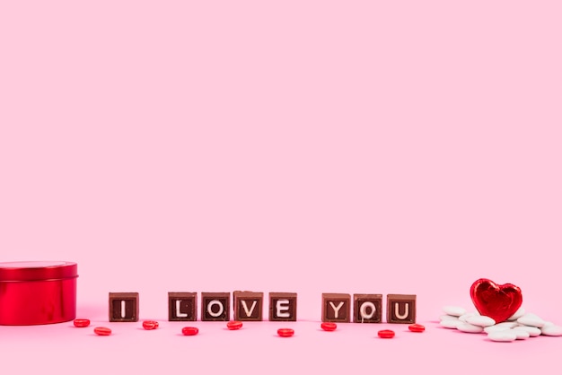 Free photo i love you inscription on chocolate pieces between box and ornament heart