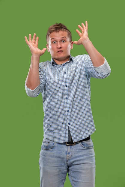 Free photo i'm afraid. fright. portrait of the scared man. business man standing isolated on trendy green studio.