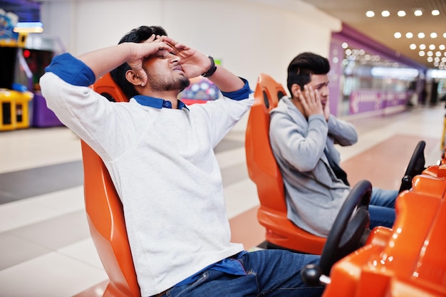 I'm loserTwo asian guys compete on speed rider arcade game racing simulator machine