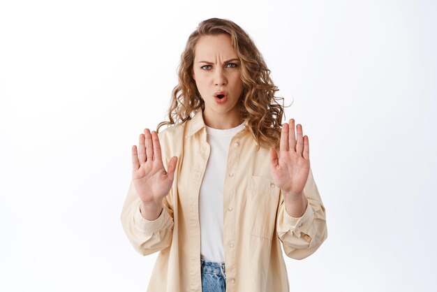 I said no Serious and determined woman refusing showing blocking stop gesture with stretched hands rejecting bad offer prohibit something white background