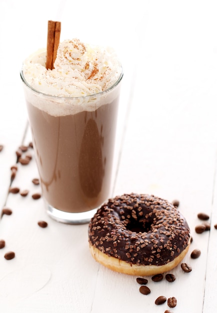 Ice coffee with whipped cream and donut 