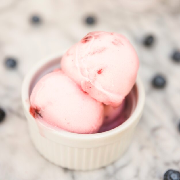 Ice cream balls in bowl near berries