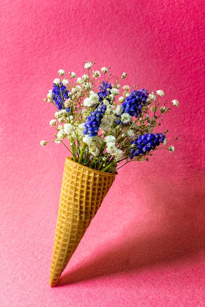 분홍색 벽에 꽃과 아이스크림 콘입니다. 측면보기, 복사 공간, 봄 꽃 개념