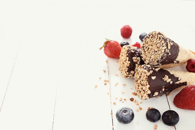 Ice cream cones with almond, chocolate and berries