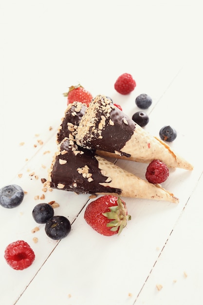 Ice cream cones with almond, chocolate and berries