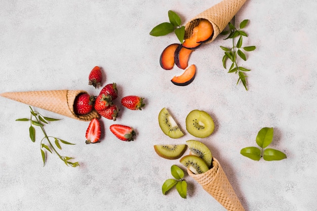 Ice cream cones with fruits on table