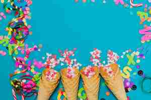 Free photo ice cream cones with hearts and confetti on a blue background