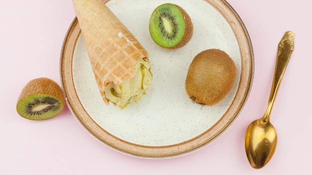 Gelato vicino a cucchiaio e kiwi sul piatto