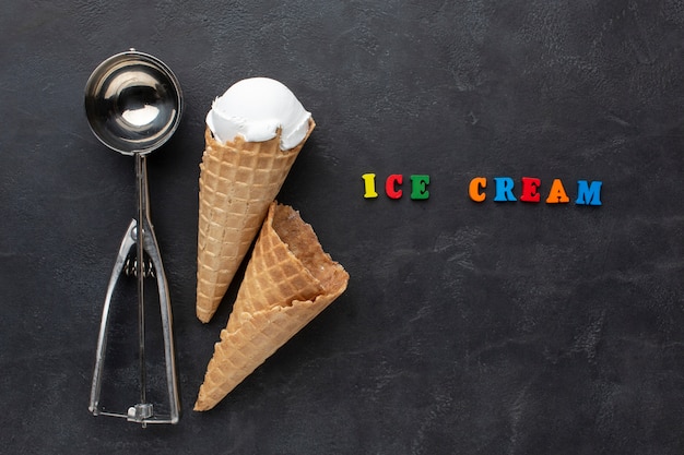 Ice cream scoop beside ice cream cone