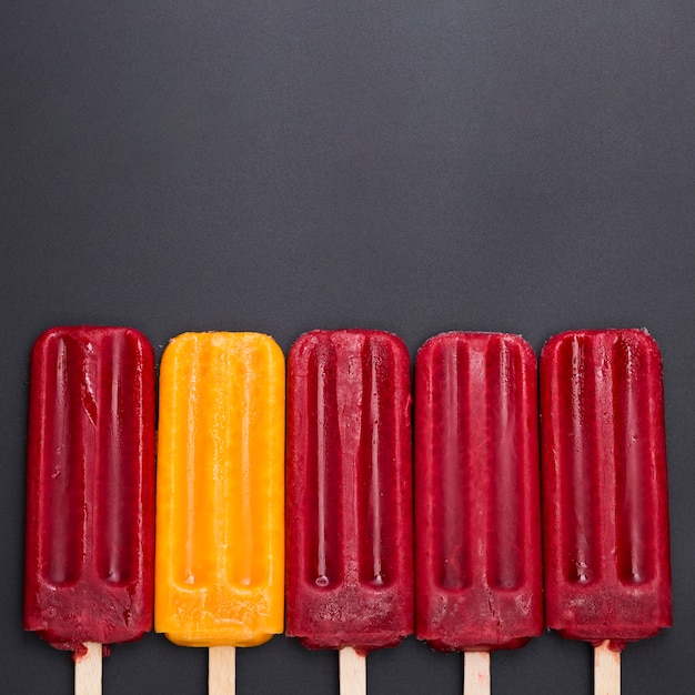 Ice cream on stick aligned on table