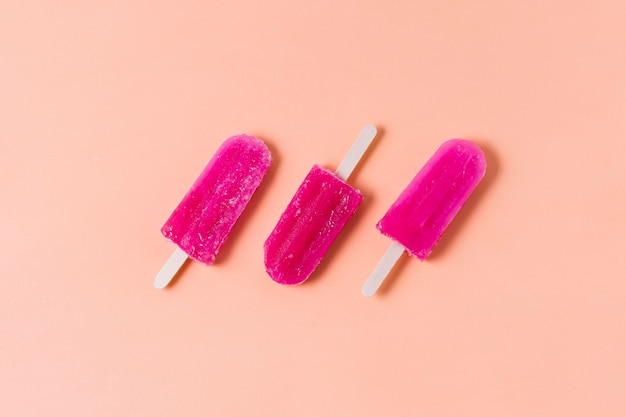 Ice cream on stick aligned on table