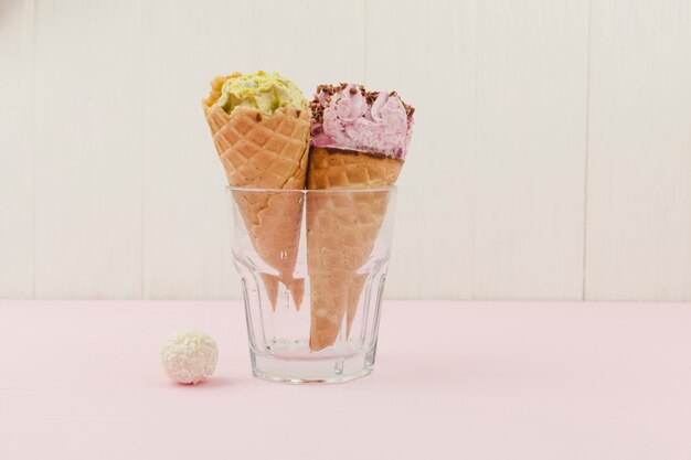 Ice creams in glass near sweet bauble on board