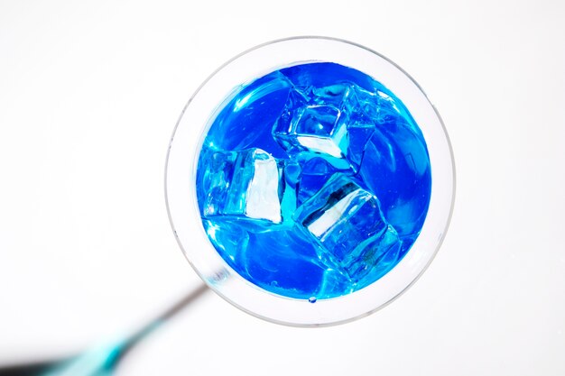 Ice cubes in the blue cocktail martini glass isolated on white background