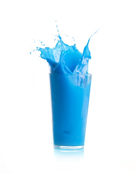 Лед падают в стакан с голубым напитком