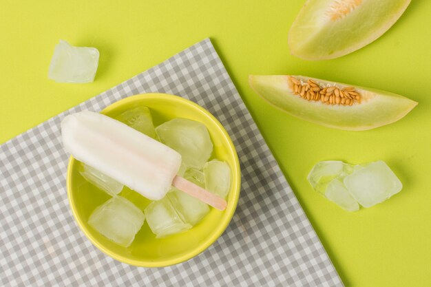 Ice lolly in bowl near napkin and fresh fruits