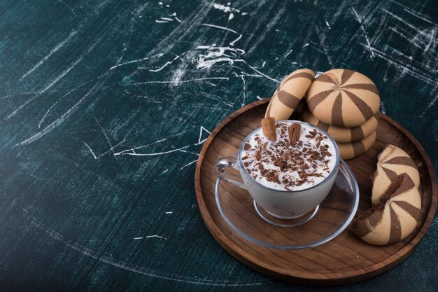 Icecream with cocoa cookies in a wooden platter, angle view