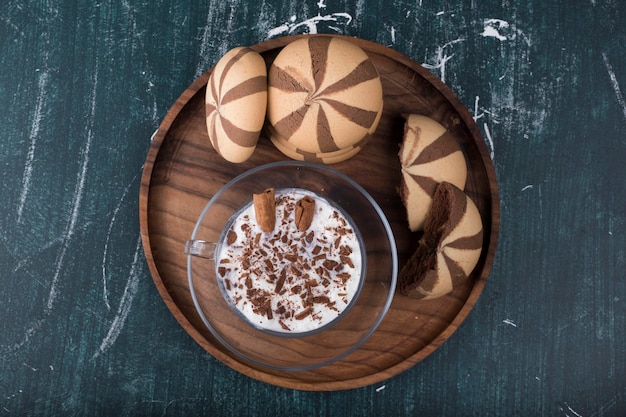 Icecream with cocoa cookies in a wooden platter, top view