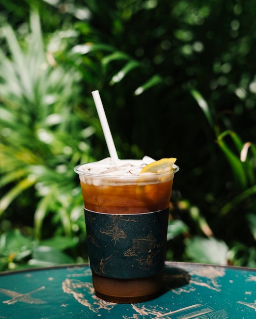 Iced cold brew coffee with lemon on a table