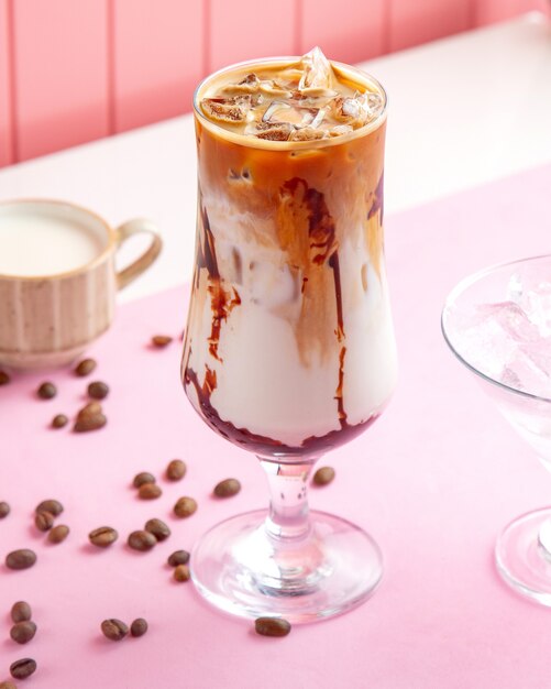 кофе мокко со льдом, холодный молочный лед и кофейные зерна на столе