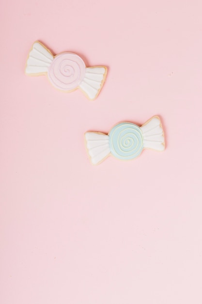 Icing cookies in chocolate shape against pink backdrop