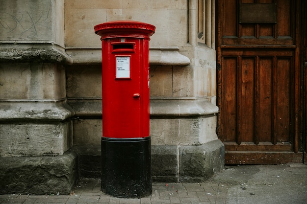 Iconic red British mailbox in a city