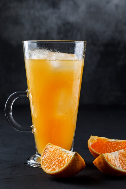 Icy orange juce in a glass cup with orange slices