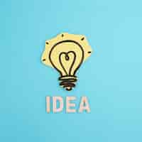 Free photo idea word with drawn yellow light bulb on blue backdrop