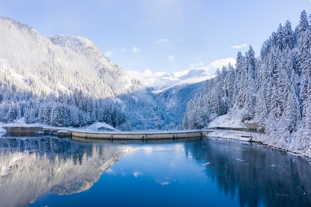 눈 덮인 산의 목가적 인 겨울 풍경과 스위스의 수정 호수