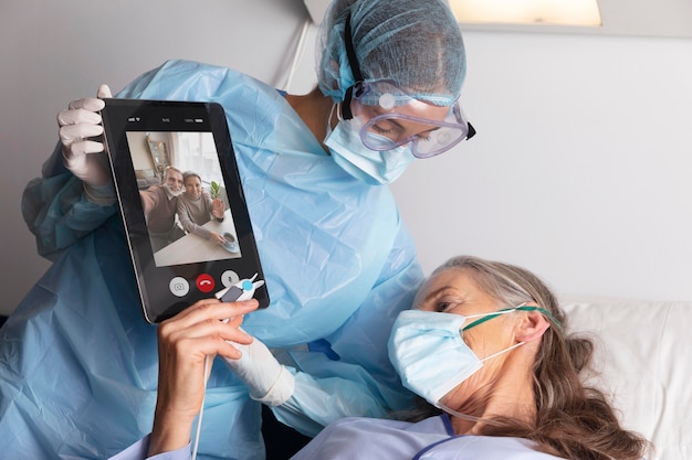 태블릿을 통해 가족과 이야기하는 병원 침대에서 아픈 여성 환자